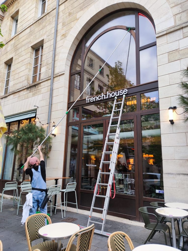 Nettoyage de vitres en hauteur au restaurant French House à Bordeaux par Leconte Nettoyage à l’aide d’une grande perche télescopique.