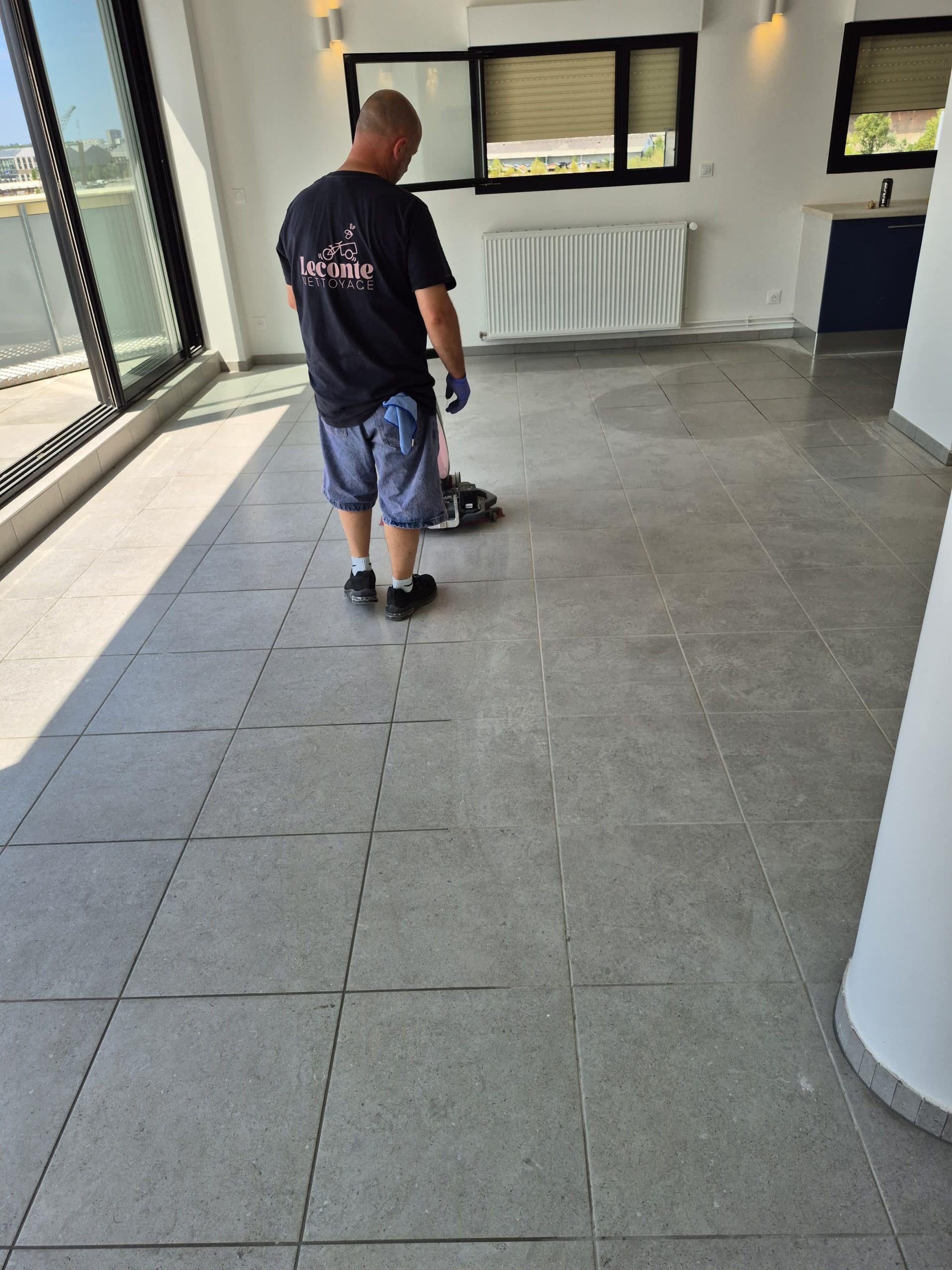 Technicien Leconte Nettoyage en train de nettoyer un sol carrelé à Bordeaux à l’aide d’une machine de nettoyage.