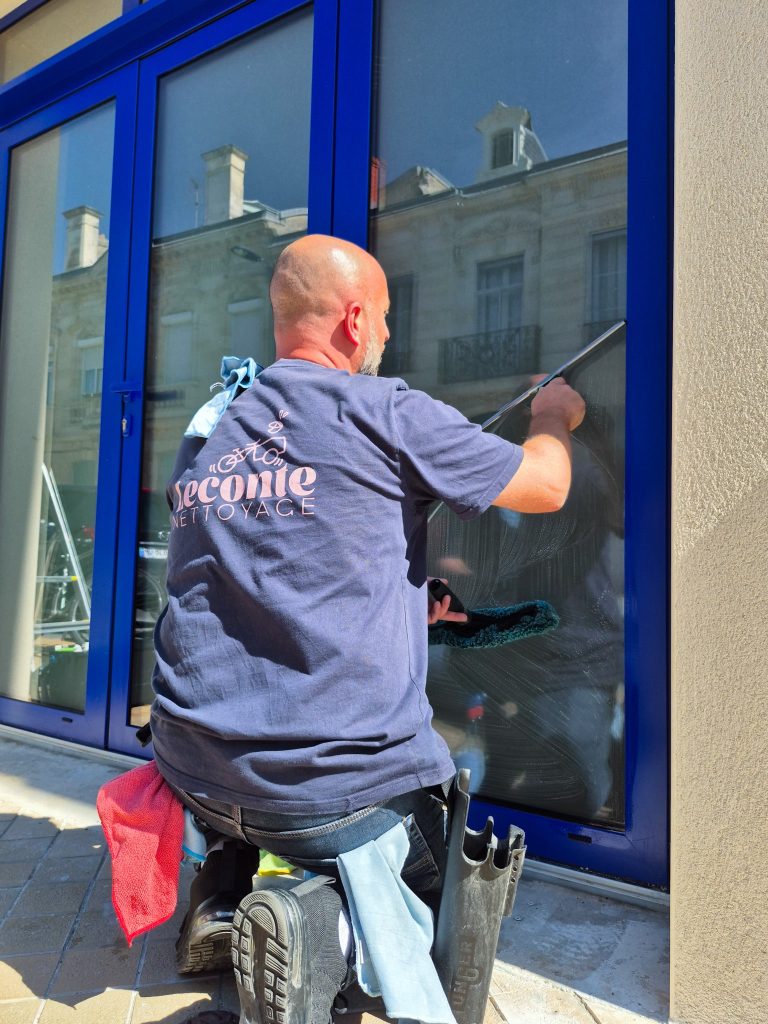 Laveur de vitres Leconte Nettoyage réalisant un lavage de vitres à Bordeaux centre dans un cabinet médical.